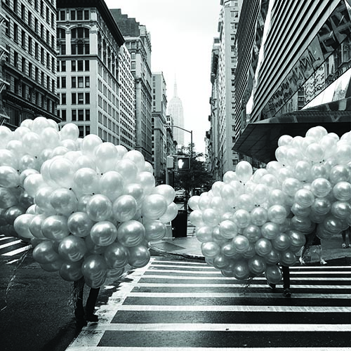 Globos Village area and people carrying balloons on the city street